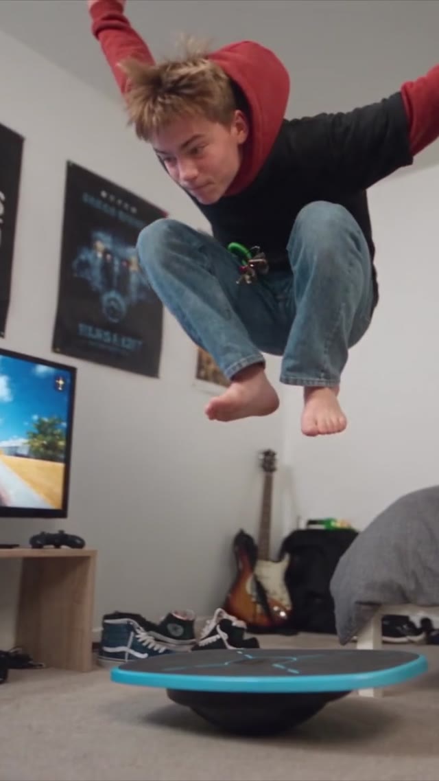 A boy mid-air above the GoBalance Sport board in his room